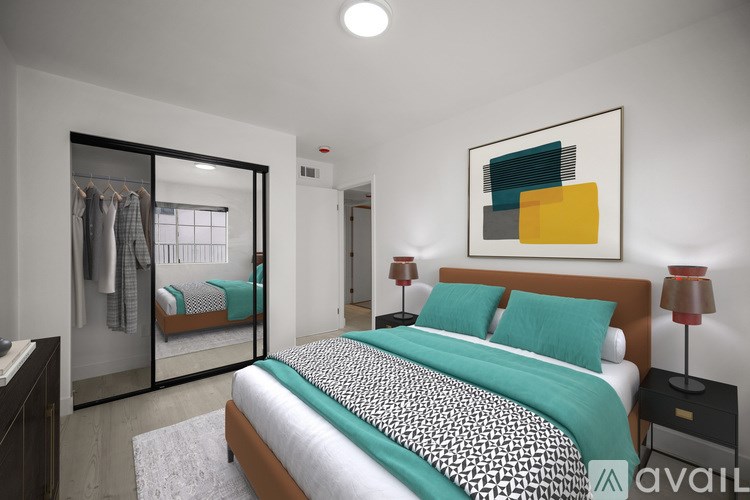 A bedroom with a large bed and a painting on the wall.