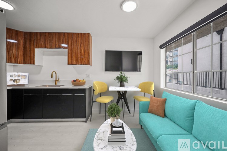 A modern living room with a kitchen area in the background.