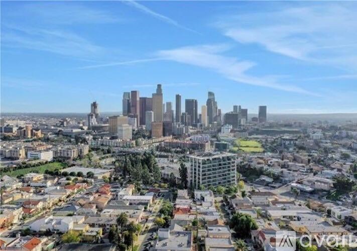 A cityscape with a mix of residential and commercial buildings under a clear sky.