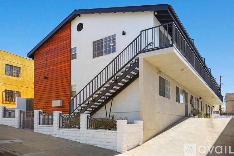 A white house with a black railing staircase.