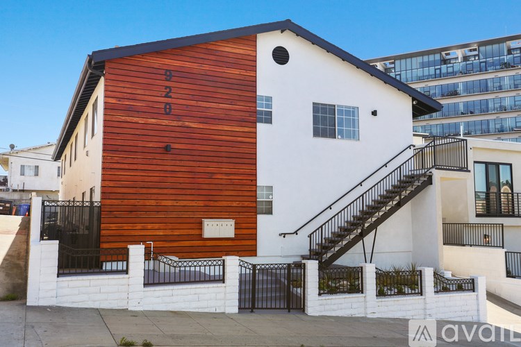 A modern house with a wooden facade and a black metal staircase.