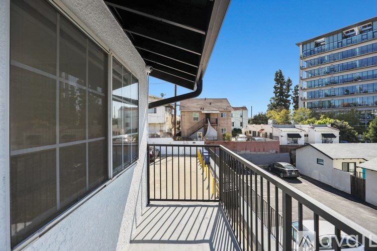 A balcony with a black railing and a white wall.