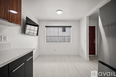 A modern kitchen with dark wood cabinets and a red door.