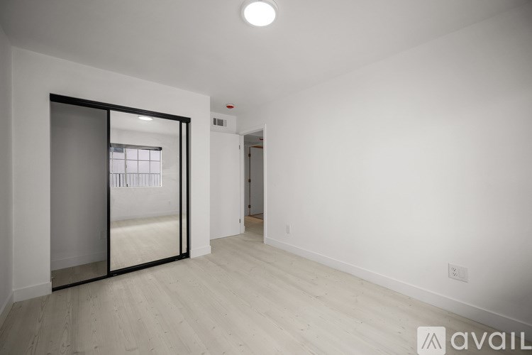 A spacious room with a sliding glass door and wooden flooring.