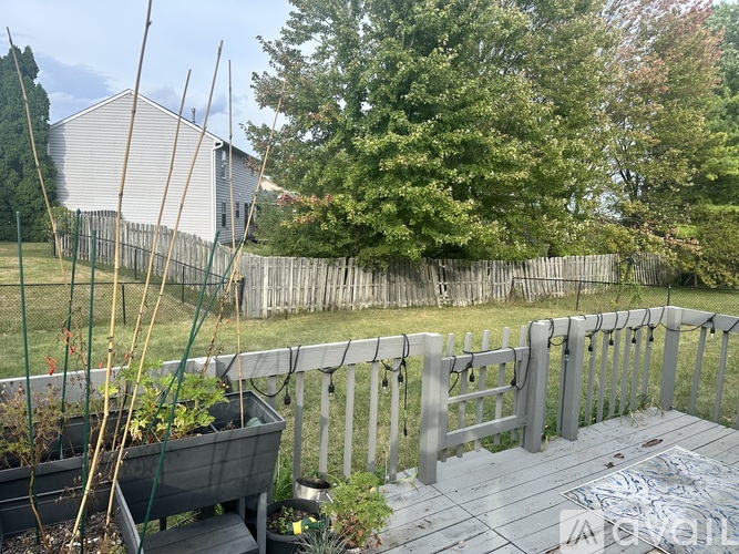A backyard with a wooden deck and a fence.