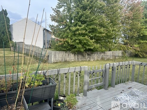 A backyard with a wooden deck and a fence.