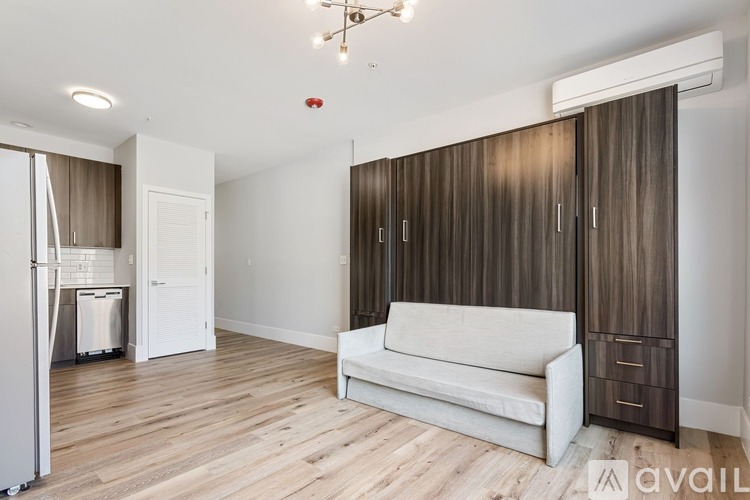 A living room with a white couch and wooden floors.