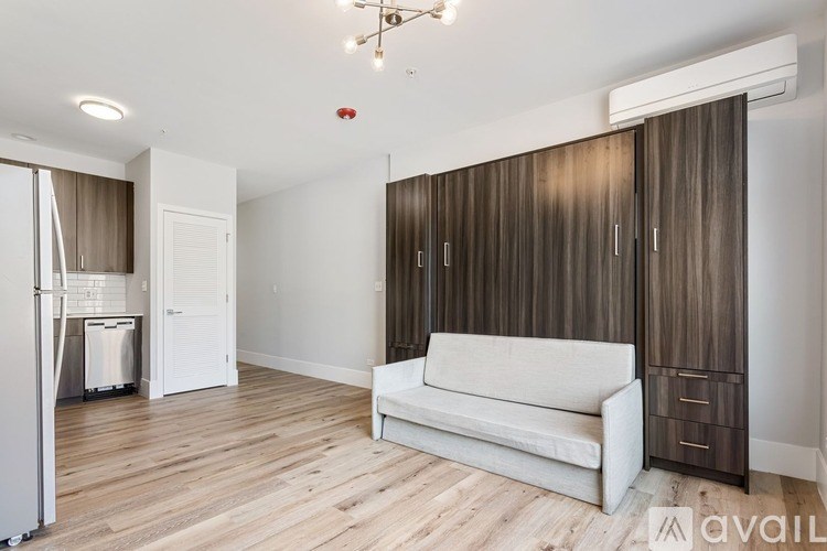 A living room with a white couch and wooden floors.
