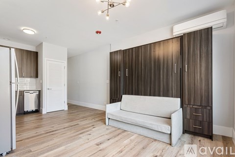 A living room with a white couch and wooden floors.