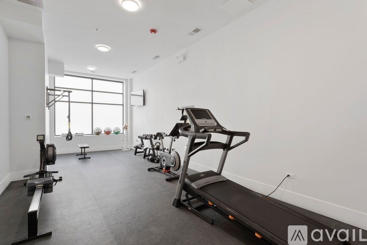 A gym with a treadmill, exercise bike, and other equipment.