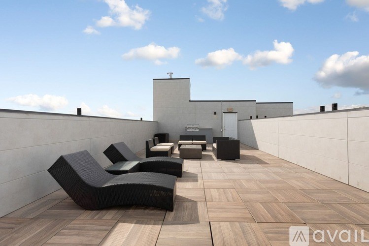 A patio with black chairs and a wooden floor.