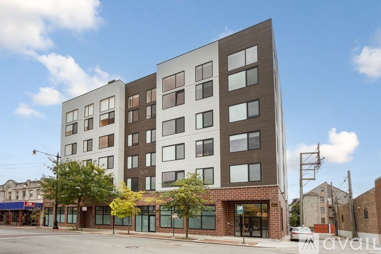 A modern multi-story building with a mix of brown and white panels.