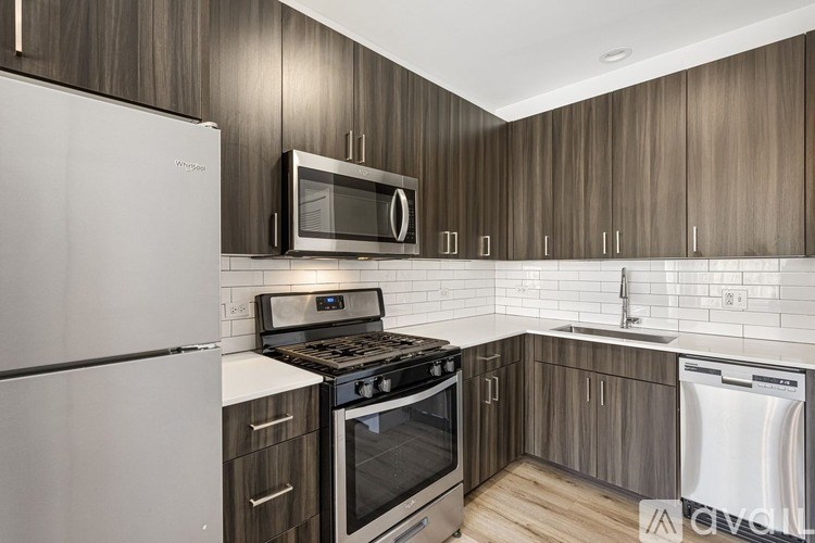 A kitchen with a white refrigerator, black stove, and wooden cabinets.