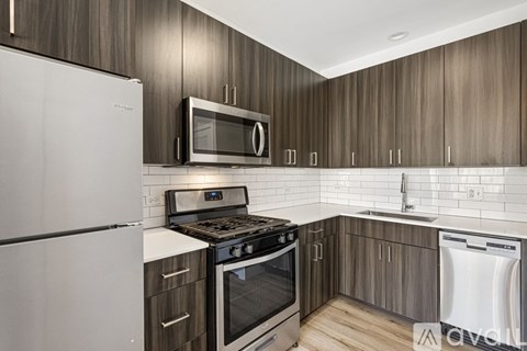 A kitchen with a white refrigerator, black stove, and wooden cabinets.