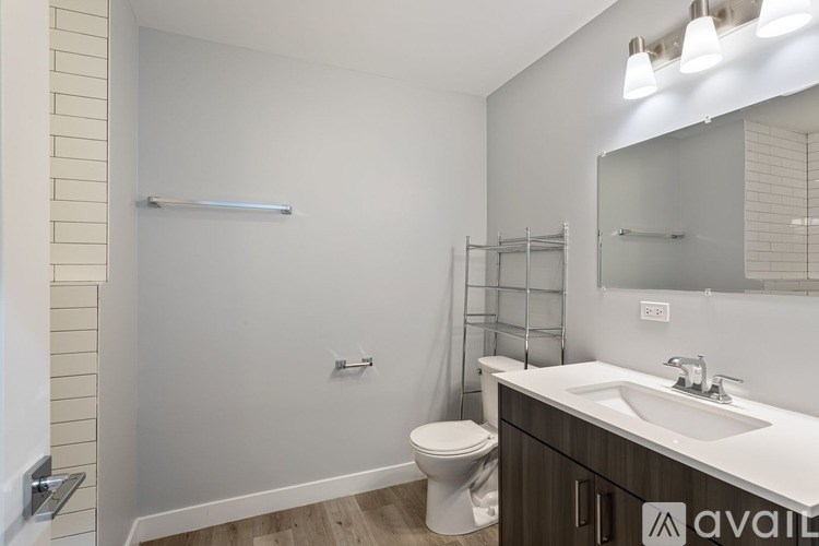 A bathroom with a toilet, sink, and mirror.