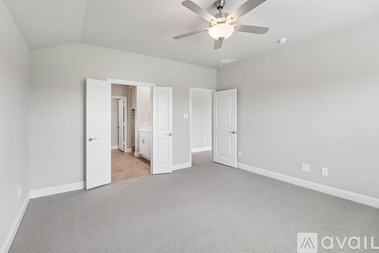 A room with a ceiling fan and carpeted floor.