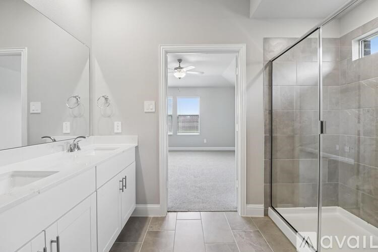 A bathroom with a walk-in shower and double sinks.
