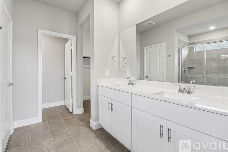 A bathroom with two sinks and a large mirror.