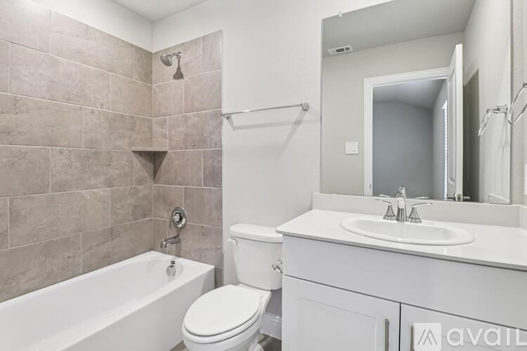 A bathroom with a white tub, toilet, and sink.