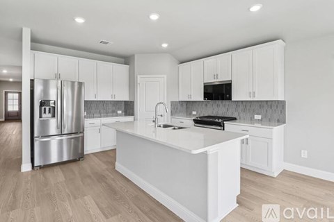 A modern kitchen with white cabinets and a central island.