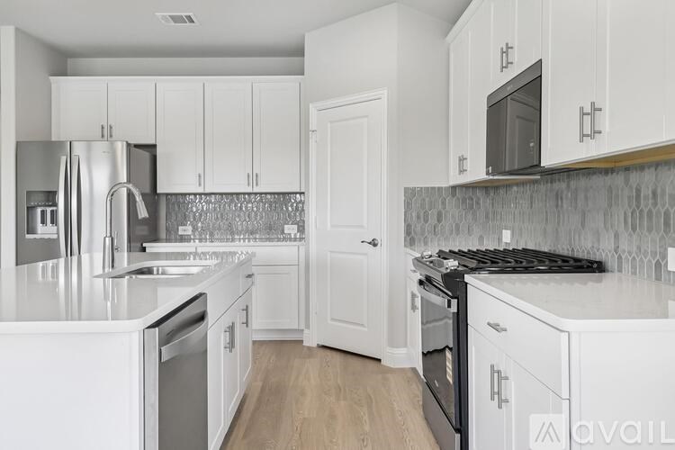 A kitchen with white cabinets and stainless steel appliances.