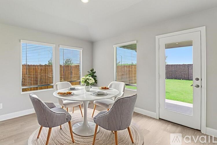 A dining room with a round table and chairs.