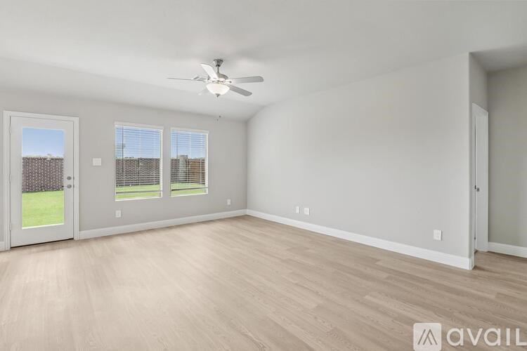 A spacious room with a ceiling fan and sliding glass doors.