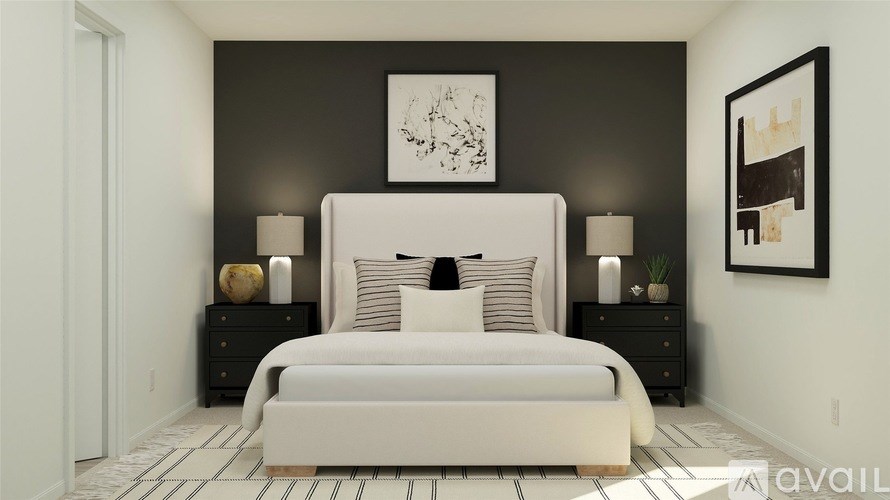 A bedroom with a large bed, two nightstands, and a framed picture on the wall.