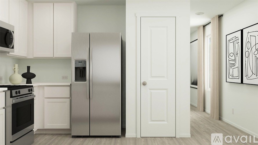 A kitchen with white cabinets and a stainless steel refrigerator.