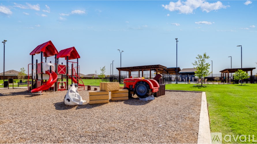 A playground with a red slide, a white ball, and a red and white striped slide.
