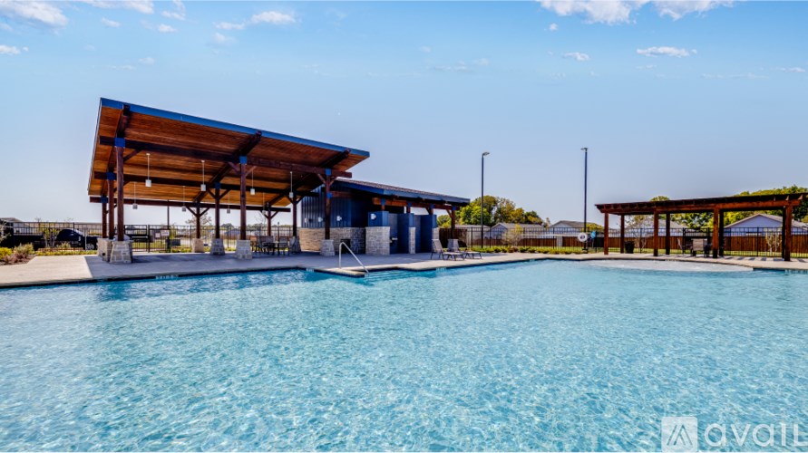 A large swimming pool with a wooden pavilion structure above it.