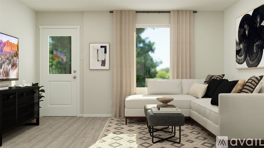 A living room with a white couch, a coffee table, and a painting on the wall.