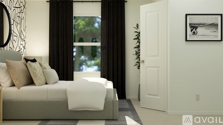 A modern bedroom with a large bed and a framed picture on the wall.