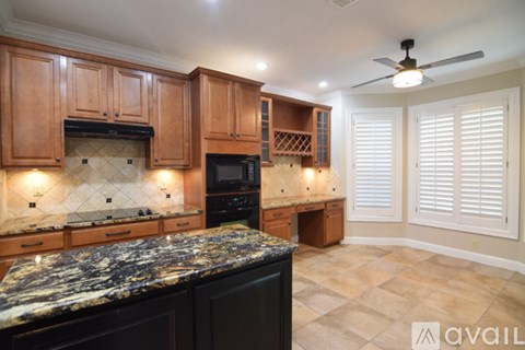 A kitchen with granite countertops and wooden cabinets.