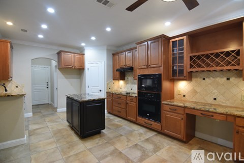 A kitchen with wooden cabinets and a tiled backsplash.