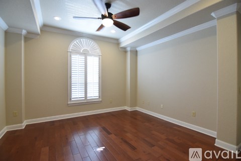 A room with a ceiling fan and a window with blinds.