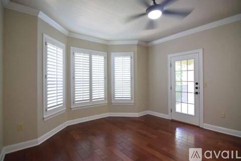A room with a ceiling fan and a door with a window.