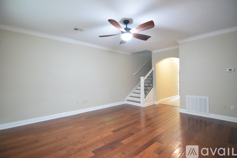 A room with a wooden floor and a ceiling fan.