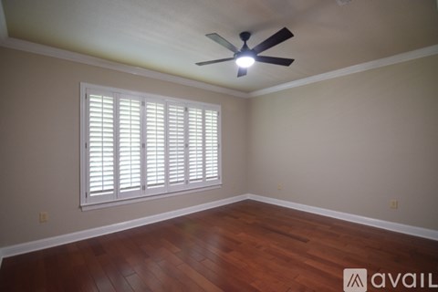A room with a ceiling fan and a window with blinds.