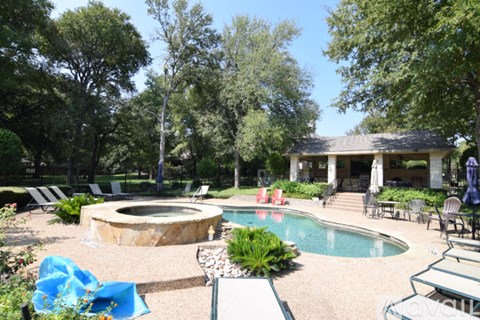 A backyard with a hot tub and a pool.