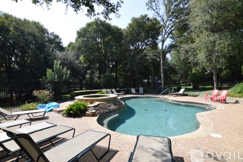 A pool surrounded by trees and chairs.