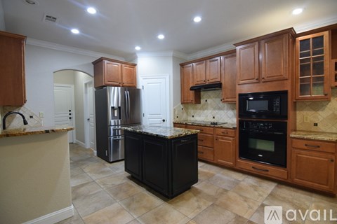 A kitchen with wooden cabinets and a fan on the ceiling.