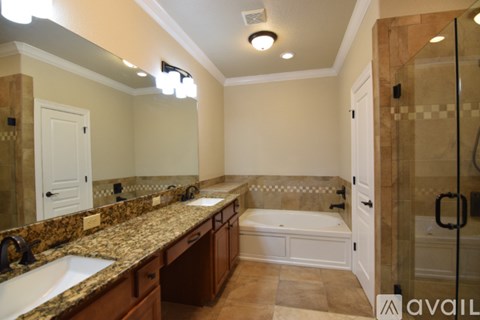 A bathroom with a marble countertop and a walk-in shower.