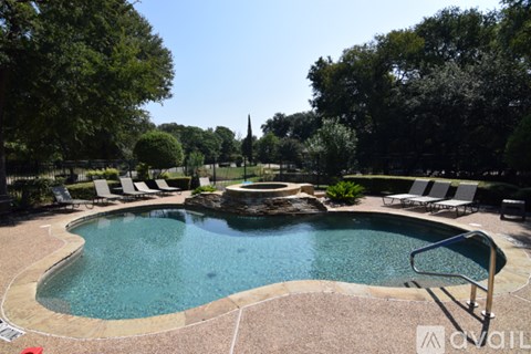 A pool surrounded by trees and lawn chairs.