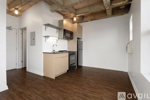 A kitchen area with wooden floors and white walls.
