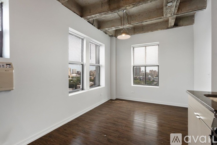 A room with wooden floors and a large window overlooking a cityscape.