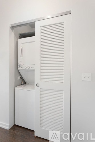 A white cabinet with a door open revealing a microwave and oven.