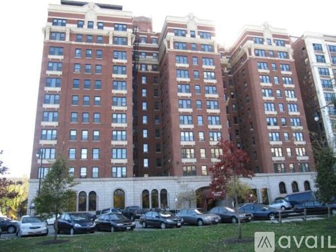 A large red brick building with a parking lot in front.