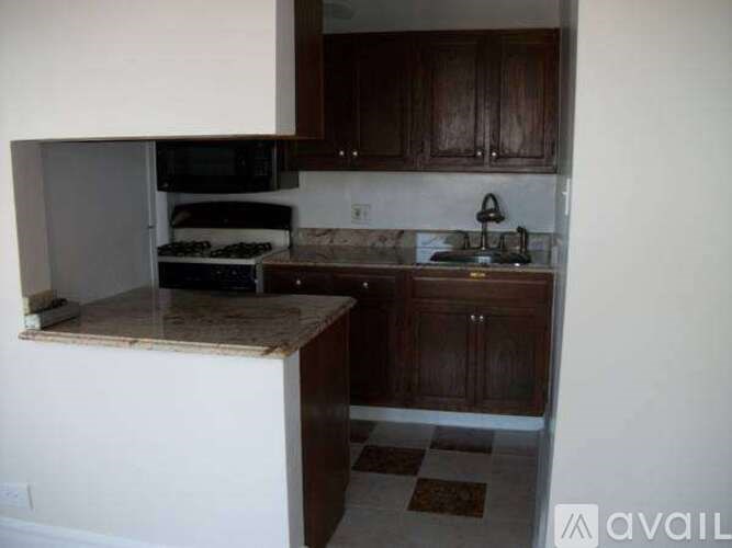 A kitchen with brown cabinets and a checkered floor.