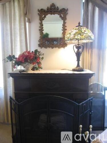 A black dresser with a mirror and a lamp on top.